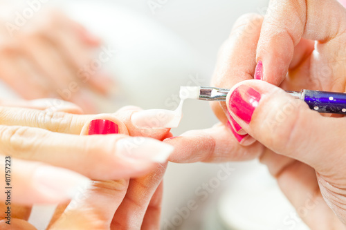 Process of nail treatment  applying white paint on fingernail