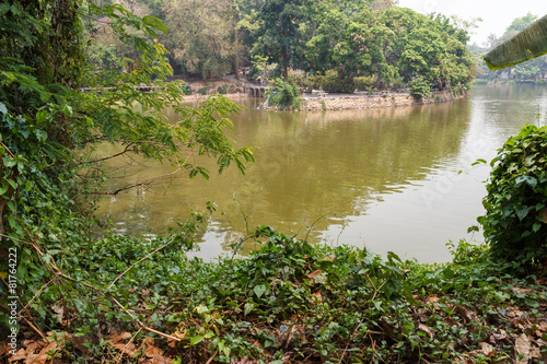 People are resting and feeding fish beside the lake