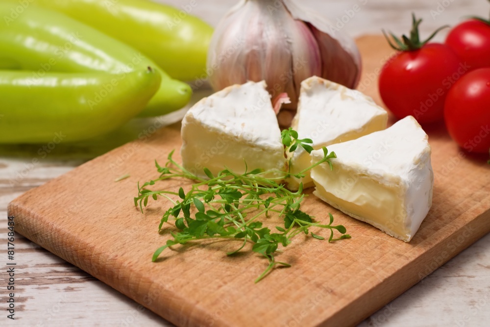 Three portions of camembert and cress on wooden board Three portions of camembert and cress on wooden board