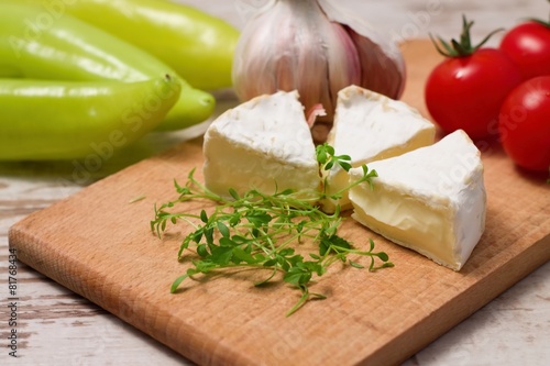 Three portions of camembert and cress on wooden board