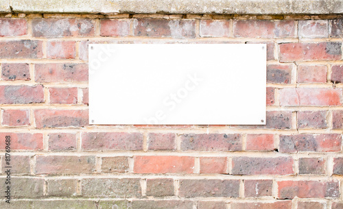 Sign board mounted on brick Wall