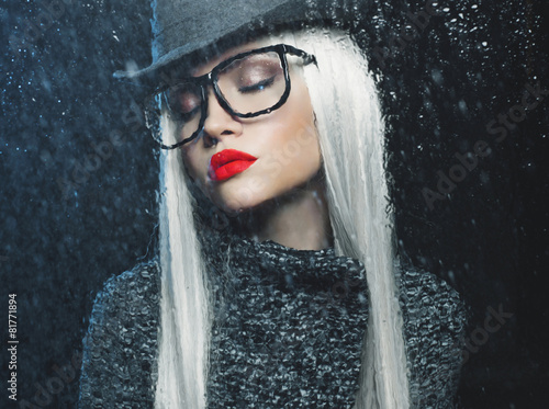 Woman looking through the wet window photo