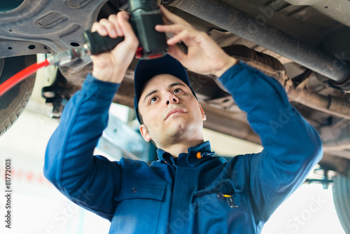 Mechanician changing car wheel in auto repair shop