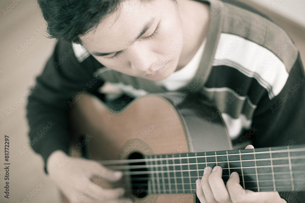 Fototapeta premium Practicing in playing guitar. Handsome young men playing guitar