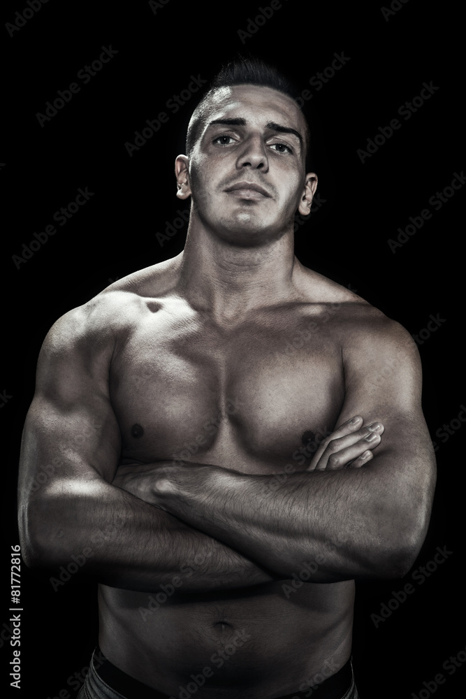 Low light portrait of bodybuilder over black background Low light portrait of bodybuilder over black background