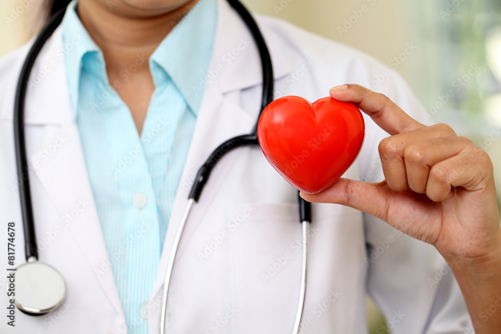 Female doctor holding a beautiful red heart shape Female doctor holding a beautiful red heart shape