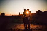 Couple is kissing at the sunset on the beach
