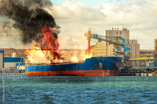 Burning cargo ship in the port.