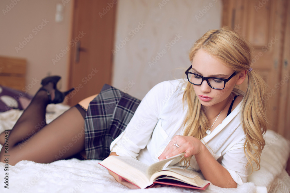 Sexy clever woman reading book on bed Stock Photo | Adobe Stock