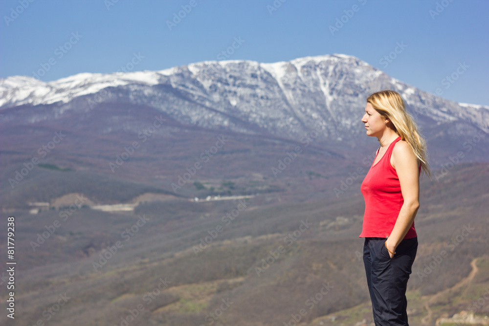 girl standing on a cliff in the mountains