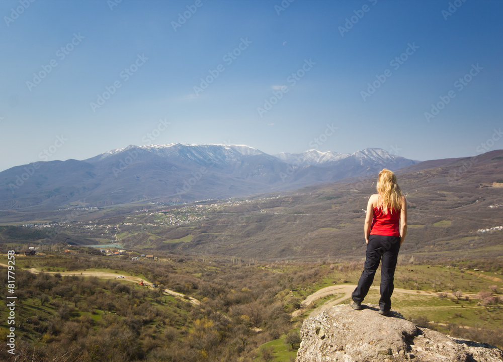 Obraz premium girl standing on a cliff in the mountains