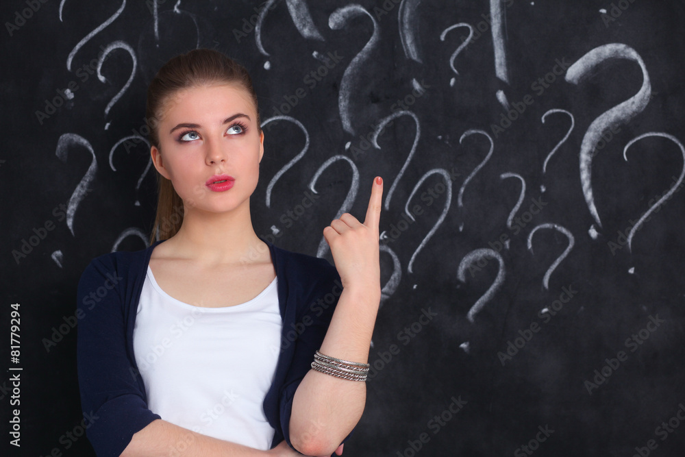 Young girl with question mark on a gray background Young girl with question mark on a gray background