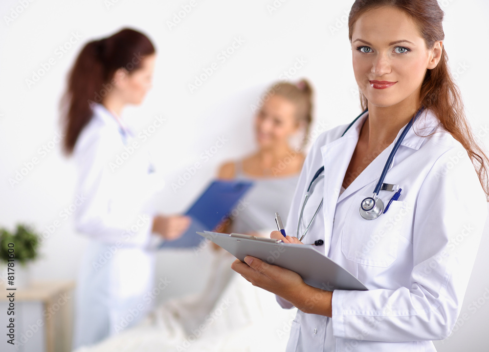 Smiling female doctor with a folder in uniform standing at Smiling female doctor with a folder in uniform standing at