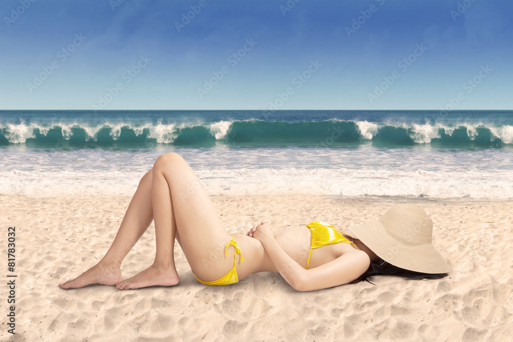 Sexy woman in bikini relaxing on beach, shot on tropical beach Sexy woman in bikini relaxing on beach, shot on tropical beach