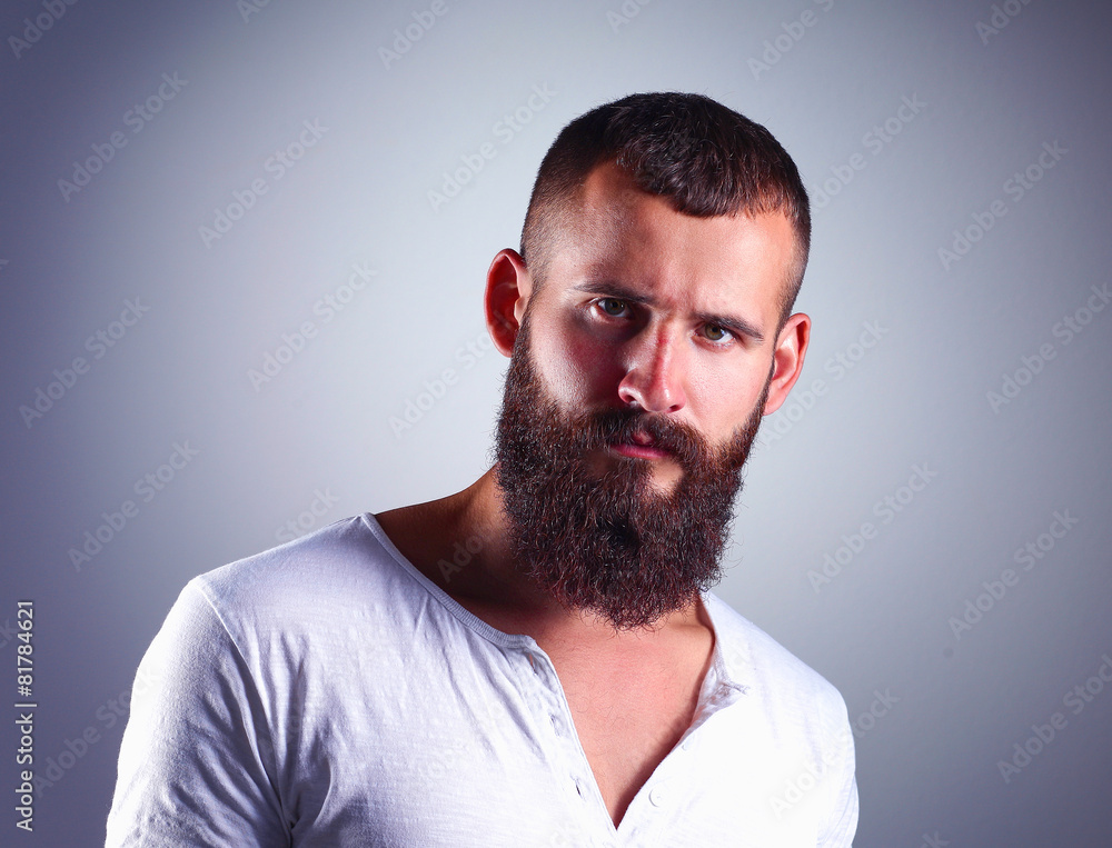 Portrait of handsome bearded man standing, isolated on grey Portrait of handsome bearded man standing, isolated on grey