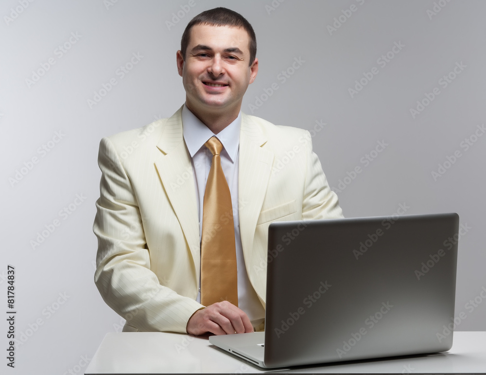 A man in a white suit sitting with a laptop. Makes hand gestures A man in a white suit sitting with a laptop. Makes hand gestures