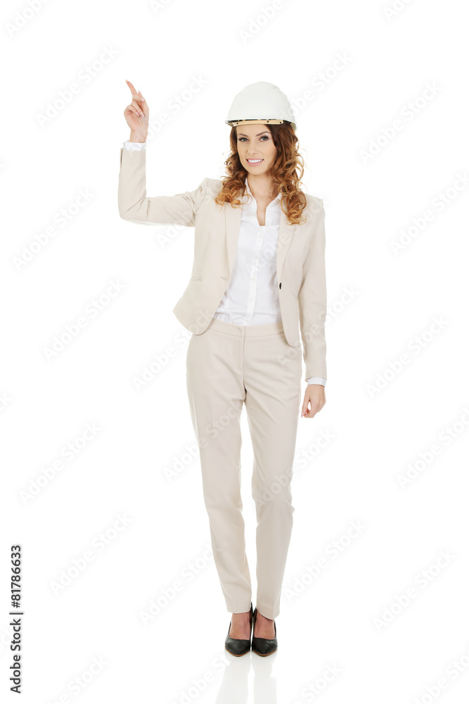 Businesswoman in white helmet pointing up. Businesswoman in white helmet pointing up.
