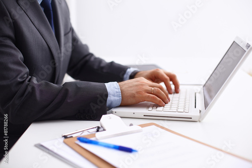 Businessman sitting in office, working with laptop computer