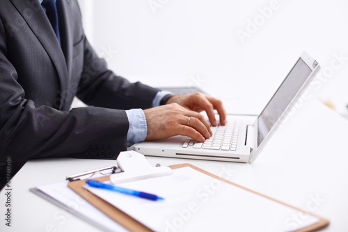 Businessman sitting in office, working with laptop computer