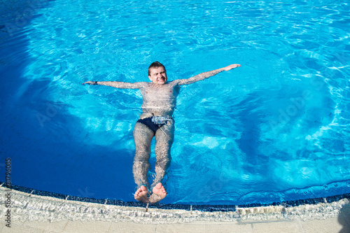 man lie on surface of water in the swimming pool