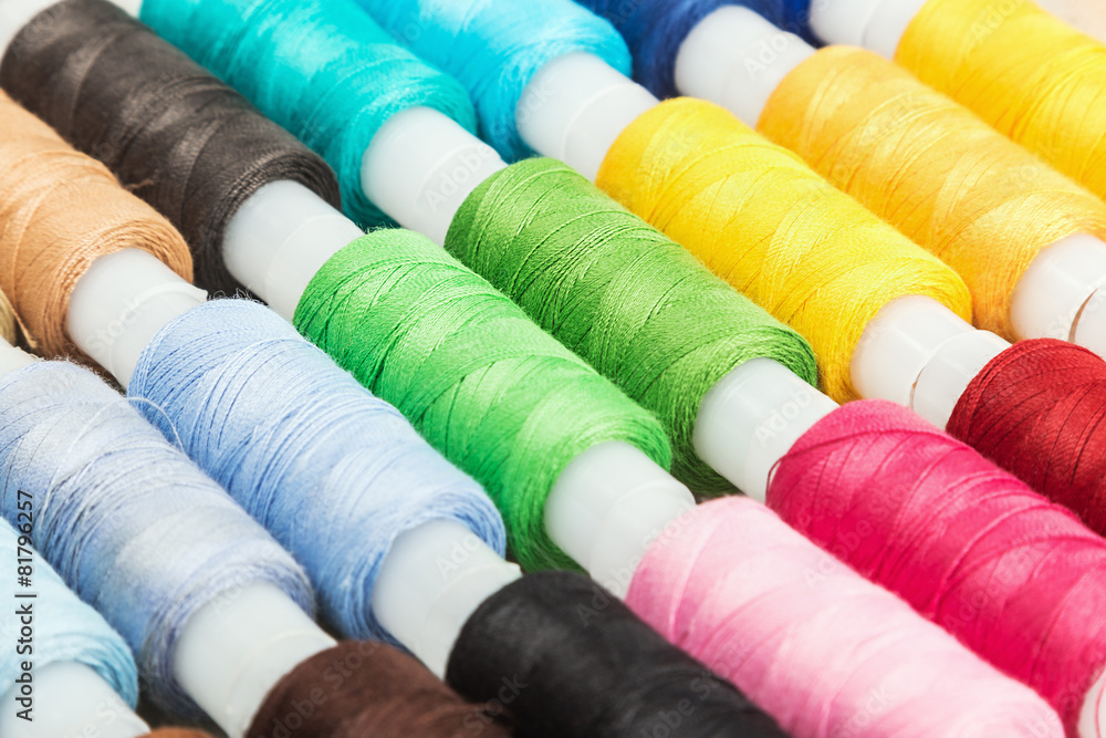 Multicolor sewing threads on wooden background Multicolor sewing threads on wooden background