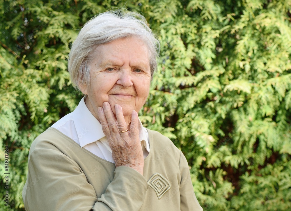 Senior woman smiling and dreaming in garden. Senior woman smiling and dreaming in garden.