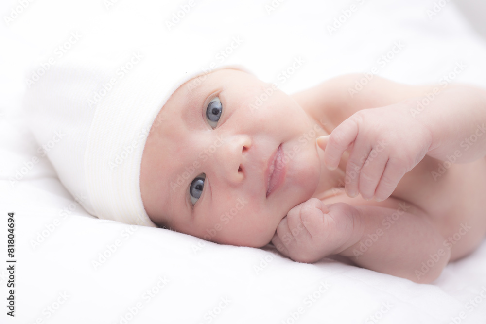 Newborn lying in white bed