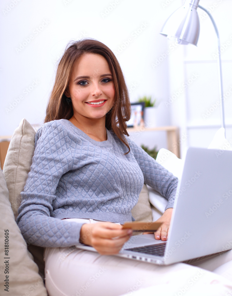 Beautiful smiling woman with laptop and a credit card Beautiful smiling woman with laptop and a credit card
