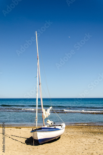 blau weisses Segelboot am Sandstrand