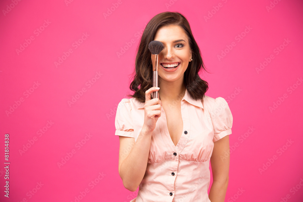 Happy young woman covering her eyes with brush Happy young woman covering her eyes with brush