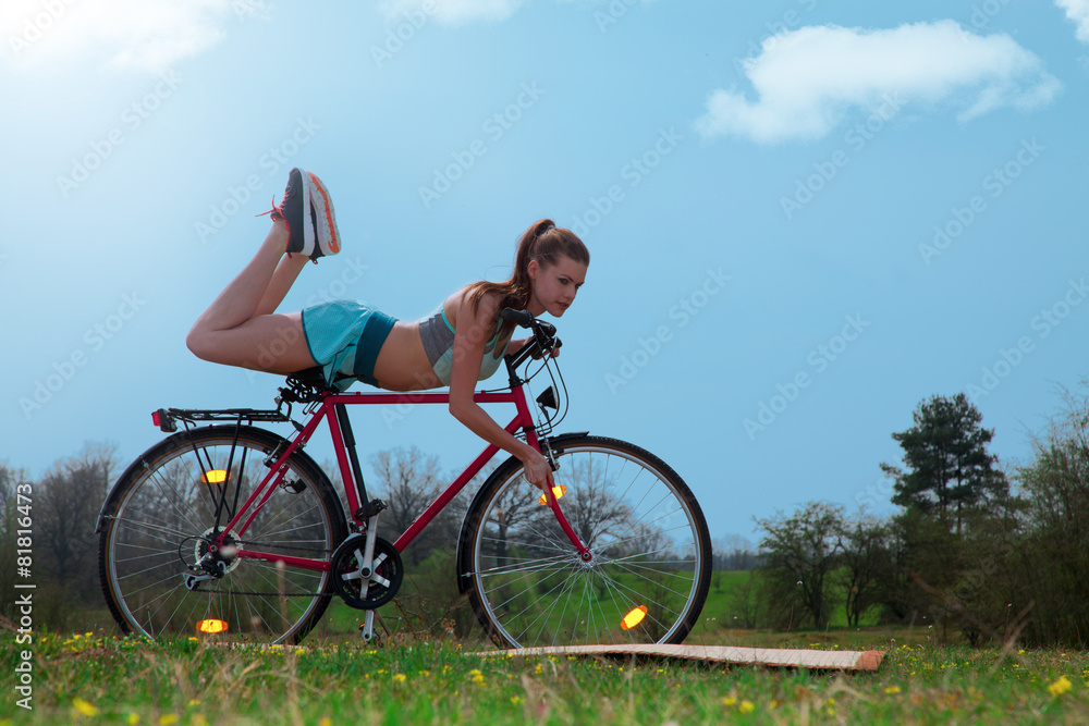 Sportliche Frau macht Fahrrad Yoga in der Natur Sportliche Frau macht Fahrrad Yoga in der Natur