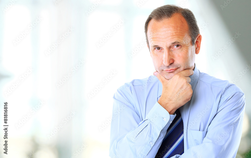 cheerful businessman with arms folded looking
