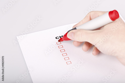 Checklist on white with marker and woman hand