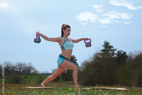 Fototapeta Naklejka Na Ścianę i Meble -  Sportliche Frau macht Yoga Sport mit Gewichten