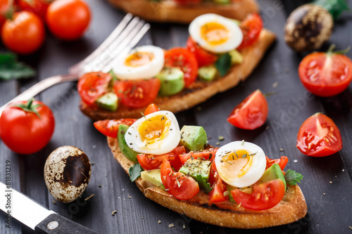 Bruschetta with tomato, avocado and quail egg