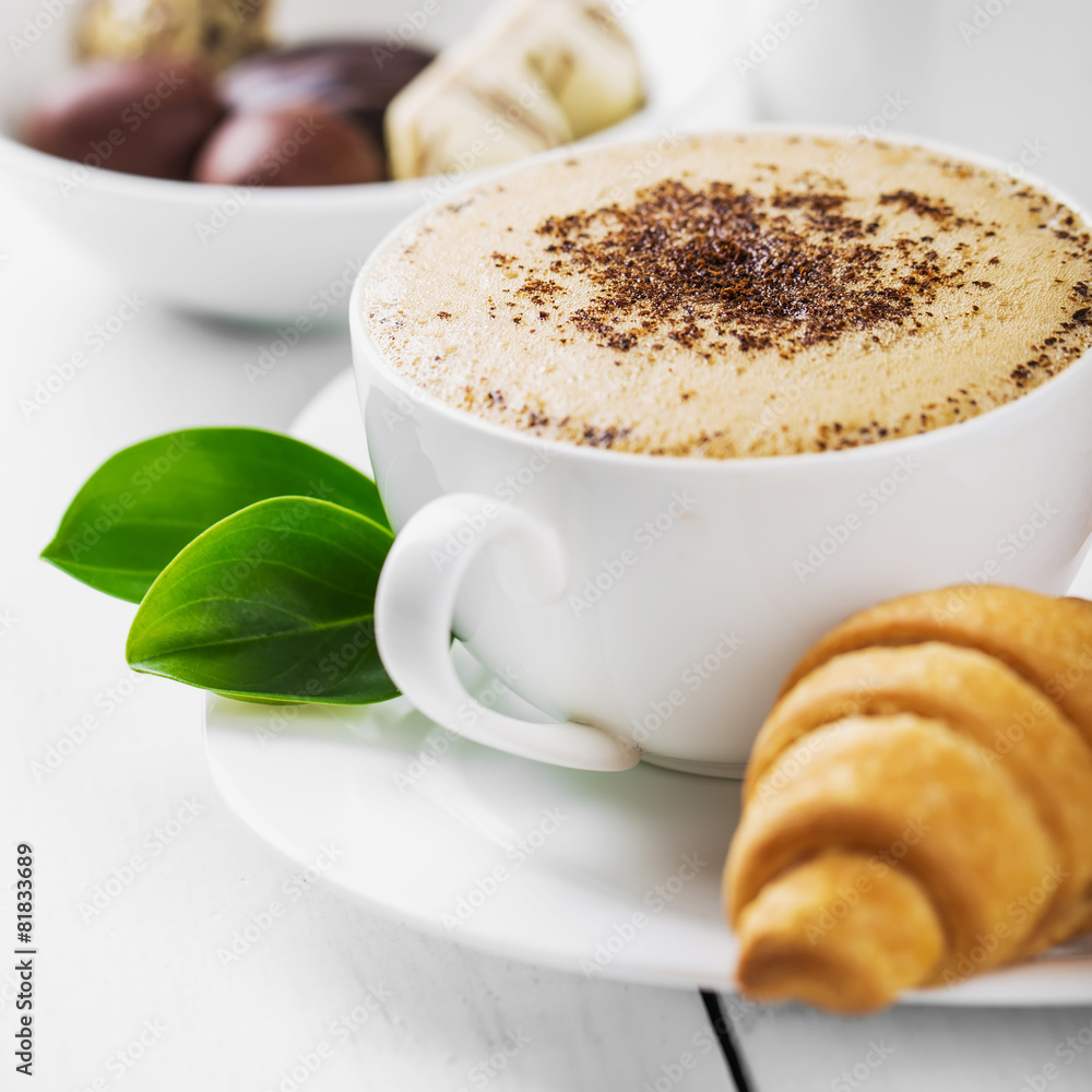 Hot cappuccino and pastries on white wooden boards Hot cappuccino and pastries on white wooden boards