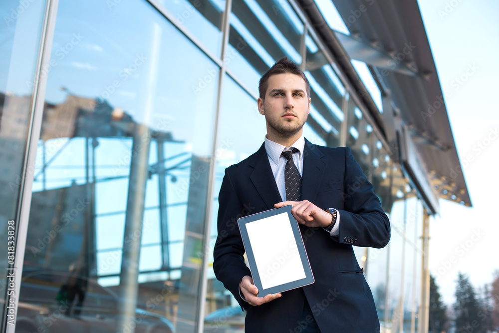Businessman holding a digital tablet computer, standing in front Businessman holding a digital tablet computer, standing in front