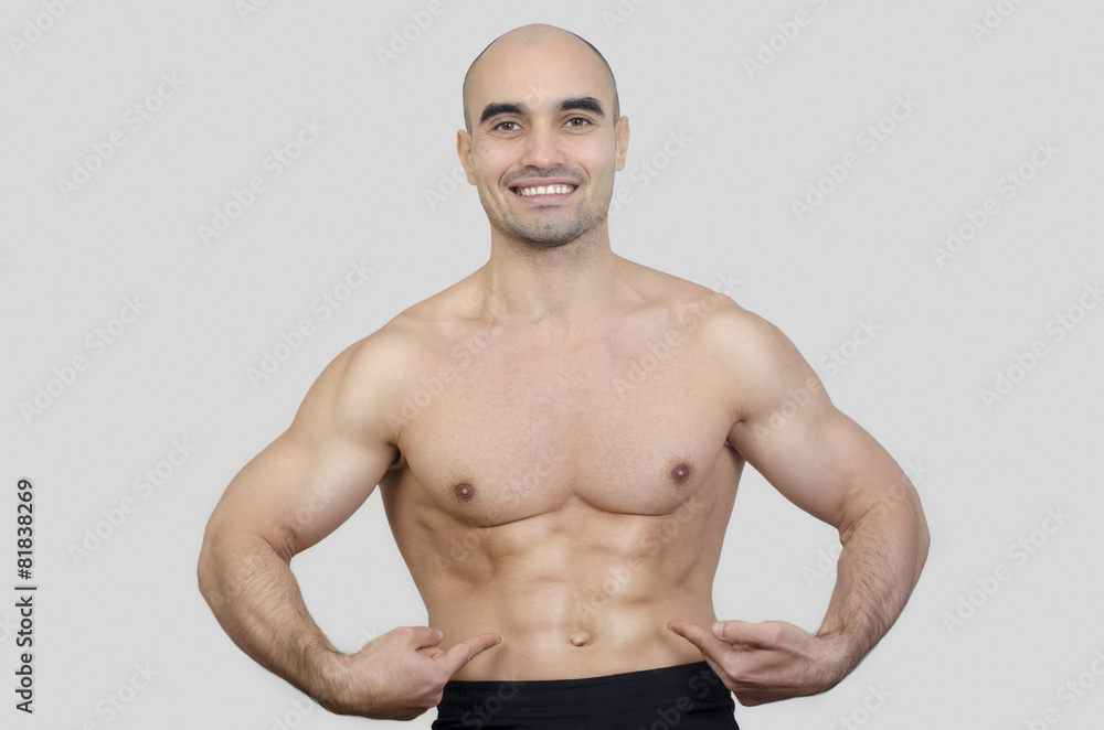 Man smiling showing abs.Man pointing showing six pack abdominal. Man smiling showing abs.Man pointing showing six pack abdominal.
