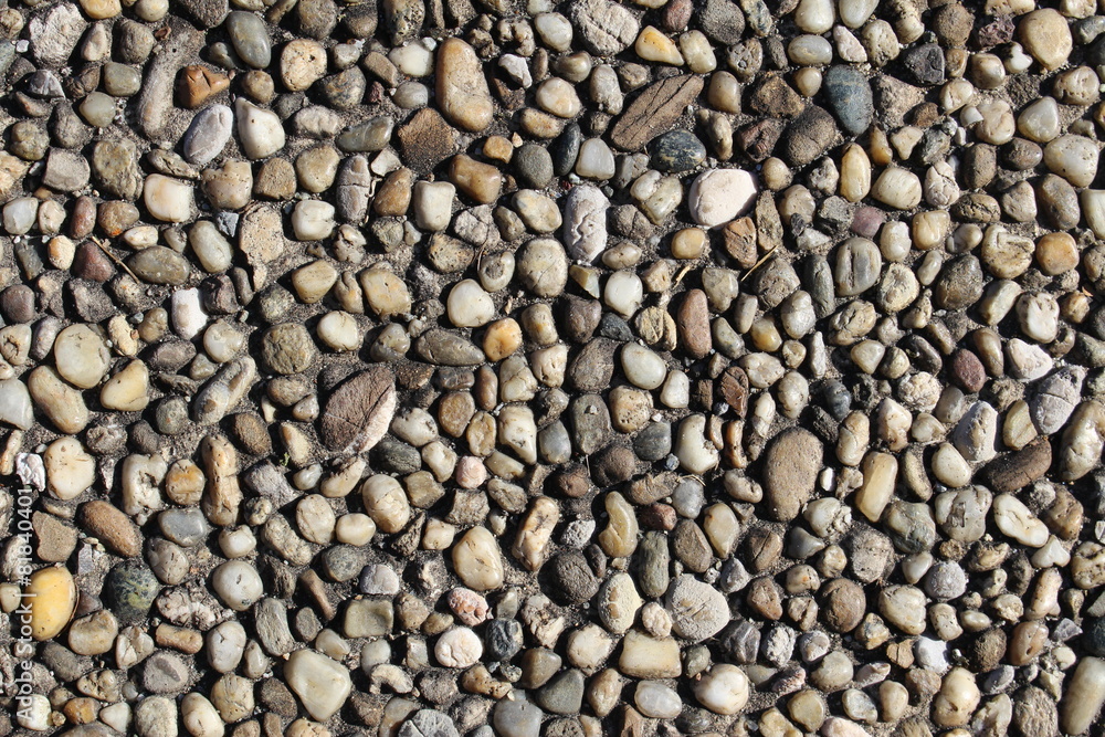 Pebbles-embedded stone texture as a background