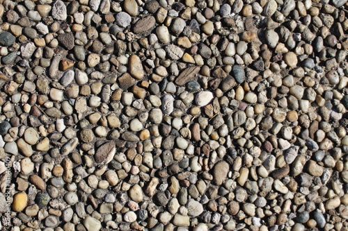 Pebbles-embedded stone texture as a background