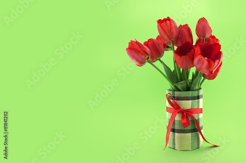 Bouquet of red tulips on green background. Spring flowers.