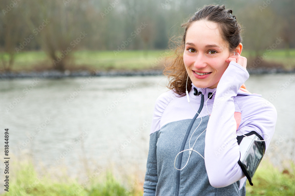 Young attractive woman adjust her music player before running Young attractive woman adjust her music player before running