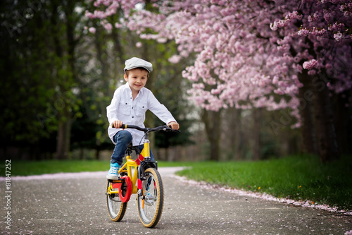 Fototapeta Naklejka Na Ścianę i Meble -  Beautiful portrait of adorable little caucasian boy, riding a bi