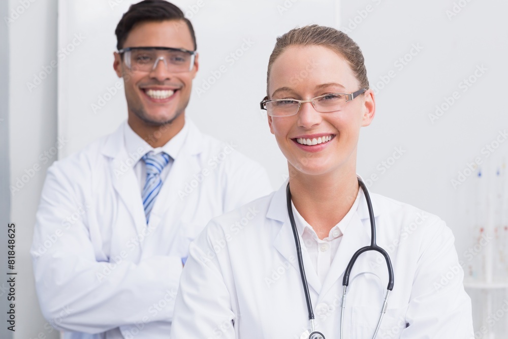 Happy scientists smiling at camera with arms crossed Happy scientists smiling at camera with arms crossed