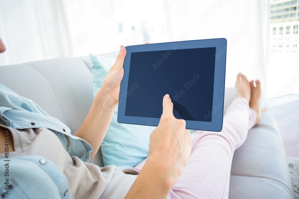 Pretty blonde woman using her tablet on the couch