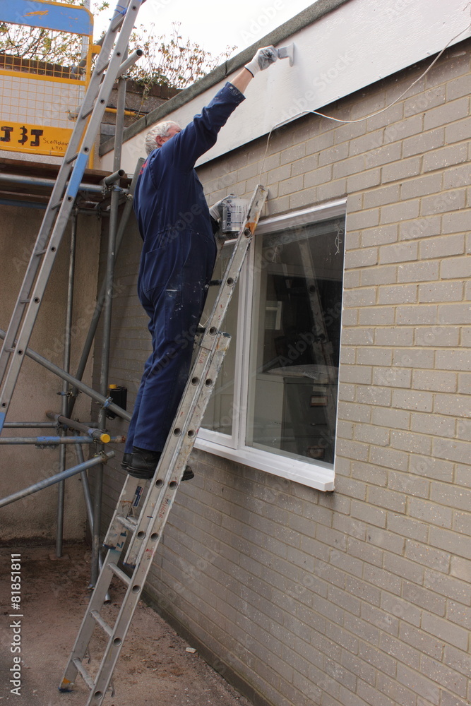 A painter working from a set of ladders A painter working from a set of ladders