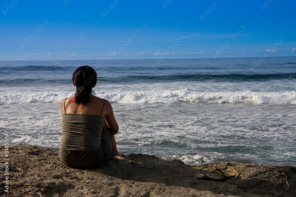 Frau am Strand genießt Blick auf Meer