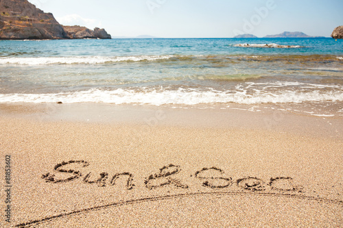 Hand made text in sand on a beach - Sun and Sea