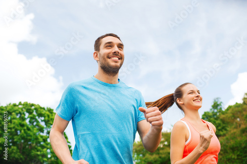 smiling couple running outdoors