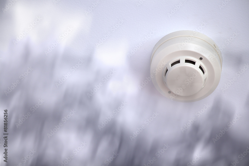 A smoke detector installed at a ceiling with smoke A smoke detector installed at a ceiling with smoke
